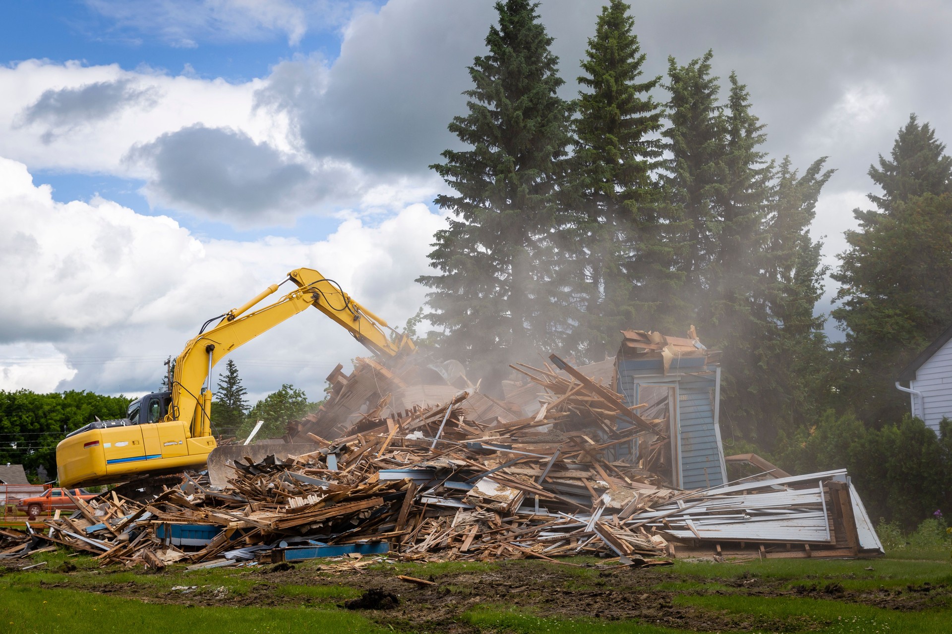 heavy duty machine demolishing a wood building