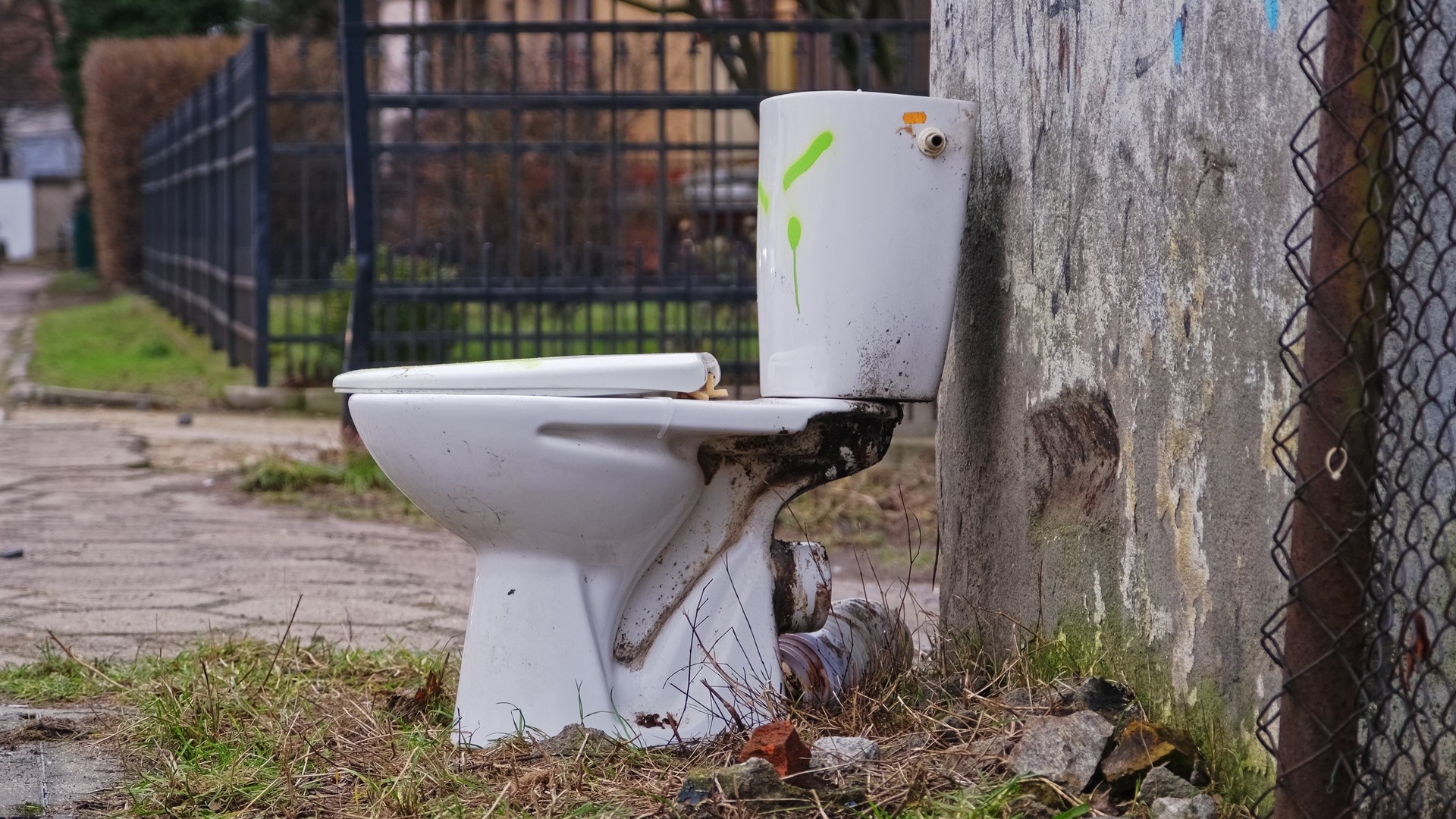 Old Toilet Bowl Dumped Outdoors during Apartment Renovation for Curb Side Pickup by City Cleaning Service Fixed